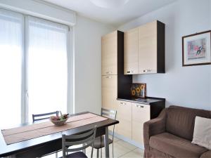 una cucina e una sala da pranzo con un tavolo e un divano di Simplistic apartment in Dervio with balcony terrace a Dervio