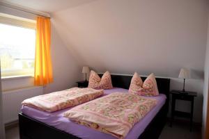 a bedroom with two beds with pink pillows at Annabell in Kühlungsborn