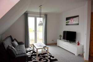 a living room with a couch and a tv at Annabell in Kühlungsborn