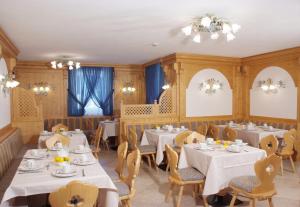 a dining room with white tables and chairs at Hotel Mountain Resort in Commezzadura