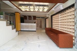 a lobby with a brown couch in a room at HOTEL GRAND SPARROW Inn in Agra +35 photos