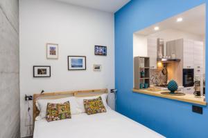 une chambre avec un lit et un mur bleu dans l'établissement Casa Giniusa by Wonderful Italy, à Catane