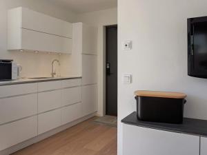 a kitchen with white cabinets and a sink and a microwave at 2 person holiday home in MARSTRAND-By Traum in Marstrand +11 photos