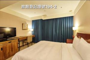 a hotel room with a bed and a desk and a television at Family Hotel Taipei in Zhonghe