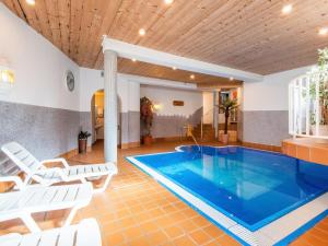 a swimming pool in a room with white chairs and a table at Pretty Apartment in Oberau with Infrared Sauna in Oberau