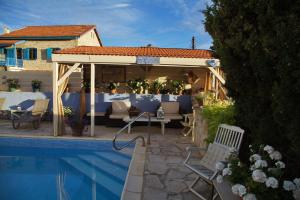 a swimming pool with a pergola next to a house at Oinochori in Vouni