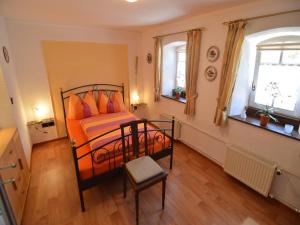 a bedroom with a bed with orange pillows at Appealing Apartment in Ittel with Garden, Parking, Bicycles in Welschbillig
