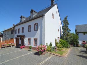 a large white building with flowers in a courtyard at Appealing Apartment in Ittel with Garden, Parking, Bicycles in Welschbillig