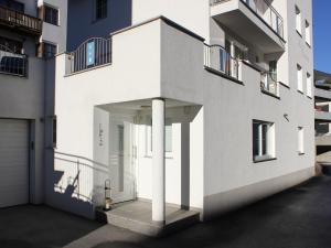 eine weiße Fassade eines Gebäudes mit einer Garage in der Unterkunft Modern Apartment in Fiss at Ski Bus Stop in Fiss