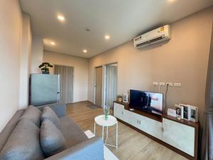 a living room with a couch and a flat screen tv at ไรท์ อพาร์ทเม้นท บาย กู๊ดดี in Ban Liap +3 photos