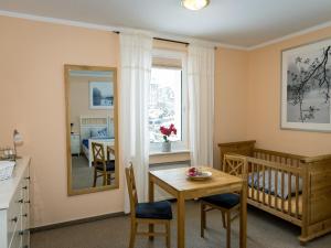 a room with a crib and a table and a dining room at Large apartment in the beautiful Sauerland with garden, patio and sauna in Erndtebrück