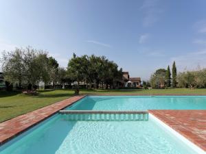 a swimming pool with blue water in a yard at Modern Holiday Home in Foiano della Chiana with Pool in Foiano della Chiana