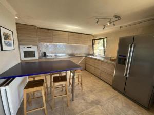 eine Küche mit einem blauen Tisch und einem Kühlschrank in der Unterkunft Villa in Tourtour with Swimming Pool in Tourtour