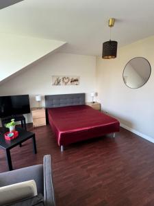 ein Schlafzimmer mit einem großen roten Bett und einem Sofa in der Unterkunft Appartement dernier étage terrasse et parking in Carantec