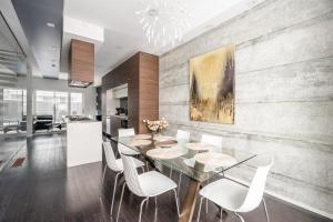 a dining room with a glass table and white chairs at Exclusive 4 Bedroom Townhouse in Toronto
