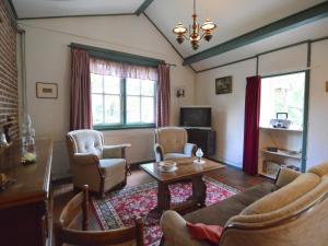 ベルヘン・オプ・ゾームにあるCozy Holiday Home in Bergen op Zoom with Gardenのソファと椅子とテーブルのあるリビングルーム