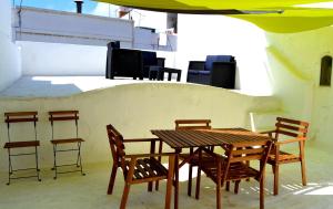 a wooden table and chairs sitting on a patio at Casa Almirante Reis - Perfect Location & Rooftop in Olhão