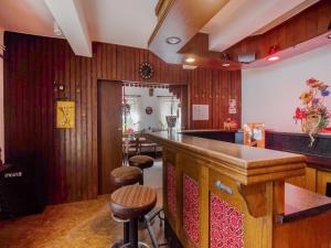 eine Bar in einem Zimmer mit Holzwänden und -hockern in der Unterkunft Cosy holiday home in Sankt Goarshausen with barbecue in Sankt Goarshausen