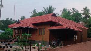 a small house with a red roof at Puthooram Veedu in Chakkarakkal