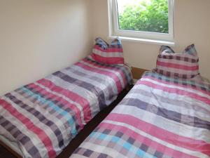 two beds sitting next to a window in a room at Holiday House in Szczecin at the lake with parking space for 4 persons in Szczecin