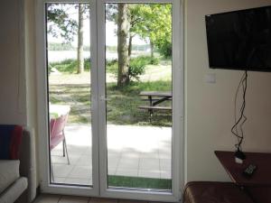 a sliding glass door with a view of a patio at Holiday House in Szczecin at the lake with parking space for 4 persons in Szczecin