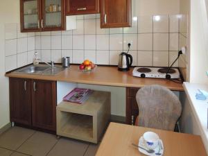a kitchen with a sink and a bowl of fruit on a table at Holiday House in Szczecin at the lake with parking space for 4 persons in Szczecin +35 photos