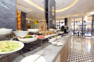 a buffet line with plates of food in a restaurant at AW Hotel Riyadh in Riyadh