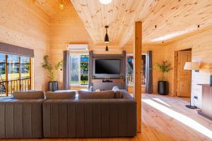 ein Wohnzimmer mit Couch und Flachbildfernseher in der Unterkunft SaffronStays The Woods - Pine Villa in Dehradun