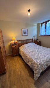 a bedroom with a bed and a lamp on a table at Maison 8 couchages avec spa in Touillon-et-Loutelet