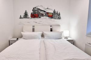 a bedroom with a bed with a train painting on the wall at Appartementhaus in Drei Annen Hohne in Drei Annen Hohne