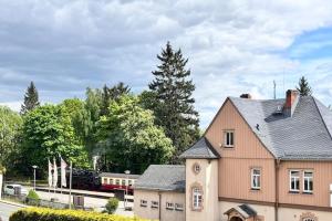 a train traveling past a house with a train station at Appartementhaus in Drei Annen Hohne in Drei Annen Hohne