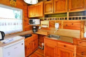a kitchen with wooden cabinets and a sink at Holiday home in Osieki near a lake in Osieki