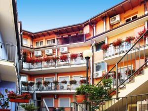 Un edificio de apartamentos con plantas en macetas en los balcones. en Apartment in the Residence dei Fiori, Baveno, en Baveno 12 fotos más