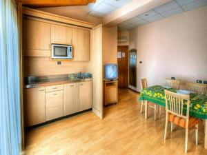 Una cocina y un comedor con una mesa y un televisor. en Apartment in the Residence dei Fiori, Baveno, en Baveno