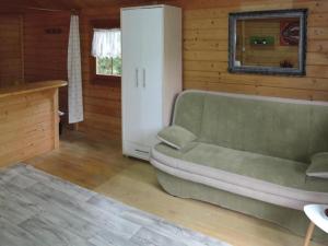 sala de estar con sofá verde y armario en Bungalow in Lubin at 300 m from the lake, en Lubin