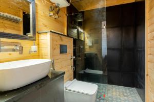 ein Badezimmer mit Waschbecken, Dusche und Toilette in der Unterkunft SaffronStays The Woods - Pine Villa in Dehradun + 39 Fotos