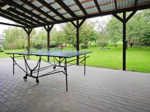 a ping pong table sitting in a pavilion with a tennis court at Holiday resort in the Müritz National Park, Mirow in Mirow