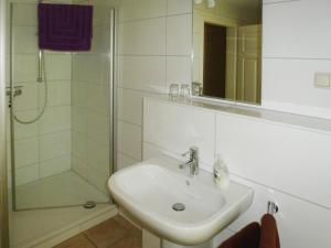un bagno bianco con lavandino e doccia di Ferienhof Landhaus Markus, Southern Switzerland a Süderschwei