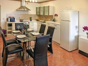 a kitchen with a table with chairs and a refrigerator at Apartments with terrace at the Kummerower See in Sommersdorf in Sommersdorf