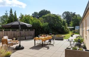 un patio con una mesa y una sombrilla en 4 Bedroom Lovely Home In Dronningmølle, en Dronningmølle 16 fotos más