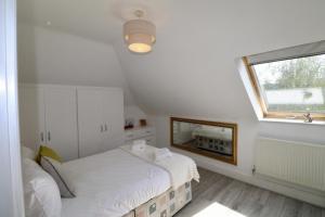 a white bedroom with a bed and a window at Egham Modern Two Bedroom Apartment in Egham