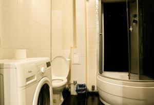 a bathroom with a washing machine and a toilet at Doba In Ua Polia27D Apartments in Dnipro +105 photos