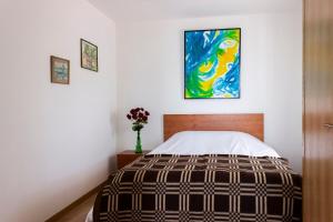 ein Schlafzimmer mit einem Bett und einem Gemälde an der Wand in der Unterkunft Casa da Zurja in Guarda