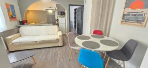 a living room with a table and chairs and a couch at Côté cour, T2 espace exterieur au calme in Lourdes +5 photos