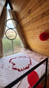 ein Zimmer mit einem Bett, das mit roten Blumen bedeckt ist in der Unterkunft Kunuz in Mīmis