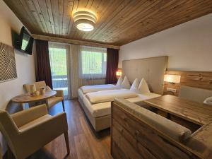 a hotel room with a bed and a table at Pension Atlantic in Badia +10 photos
