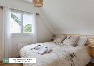 een slaapkamer met een bed met handdoeken erop bij La Villa du Bois d'Amour in Quiberon