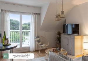 een woonkamer met een flatscreen-tv op een dressoir bij La Villa du Bois d'Amour in Quiberon