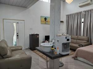 a living room with a couch and a sink in a room at Makwan Homestay B in Kubang Semang