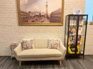 a couch in a living room with a picture on the wall at Regina Urban Beach Hotel in Lido di Jesolo